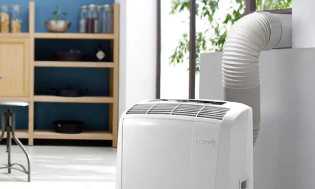 Climatiseur mobile blanc avec tuyau d'évacuation relié à une fenêtre.