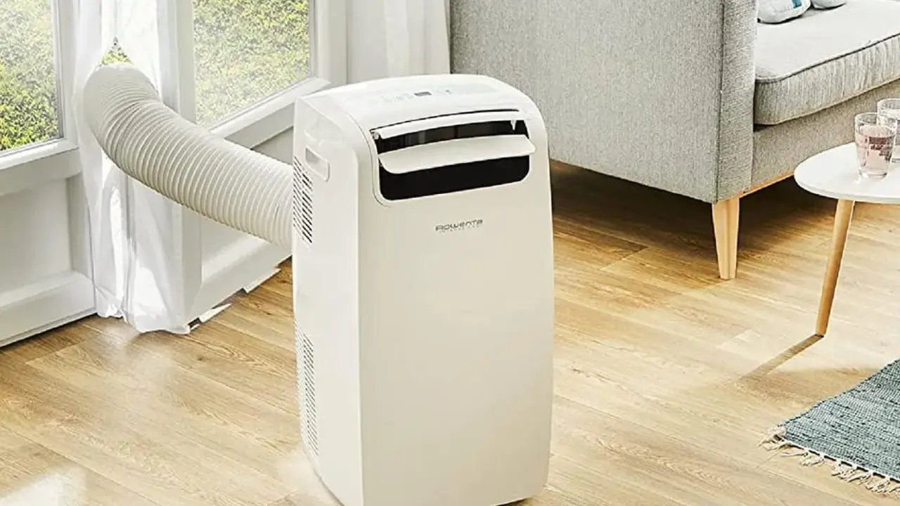 Climatiseur mobile Rowenta, la meilleur marque climatiseur mobile pour un confort optimal. Un appareil blanc avec un tuyau d'évacuation vers la fenêtre.