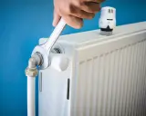 Main tenant resserre une connexion sur un radiateur qui fait du bruit.