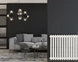 Un salon moderne avec un canapé gris, une table basse et un lustre design. À droite, un radiateur blanc classique, rappelant les anciens panneaux rayonnants.
