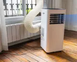 Climatiseur monobloc avec son tuyau d'évacuation vers la fenêtre. Un inconvénient : le tuyau peut être encombrant.