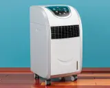 Climatiseur mobile appartement blanc, sur roulettes, avec écran de contrôle bleu. Idéal pour rafraîchir votre espace.