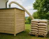 Stock de granulés de bois pour une chaudière à granulés avis. Un tuyau souple relie le silo en bois à la pile de sacs.