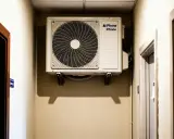 Clim dans couloir pour refroidir les chambres. L'unité extérieure d'un climatiseur est fixée au mur, prête à diffuser de la fraîcheur.