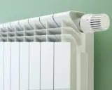 Radiateur blanc moderne avec thermostat. Le fluide caloporteur circule pour chauffer la pièce.