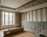 Travaux d'isolation dans un appartement : ossature métallique pour le plafond et les murs, matériaux isolants apparents.