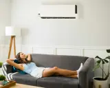 Une femme se détend sur un canapé sous un climatiseur, profitant de la puissance clim pour 40m2.