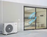 Unité extérieure d'un système de chauffage clim réversible, diffusant de l'air frais dans une pièce par une baie vitrée.