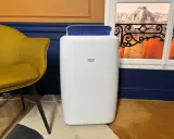 Climatiseur Beko, blanc, avec une sortie d'air bleue. Un fauteuil moutarde et une vue sur des toits parisiens. Avis positifs attendus.