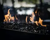 Flammes dansant sur des éclats de verre noir, évoquant le chauffage au pétrole, ses avantages et inconvénients.