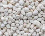 Gros plan sur des granulés blancs et irréguliers, parfaits pour la perlite isolation.
