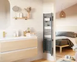 Salle de bain moderne avec meuble vasque, miroir ovale et sèche-serviettes gris. La puissance du sèche serviette assure des serviettes chaudes.