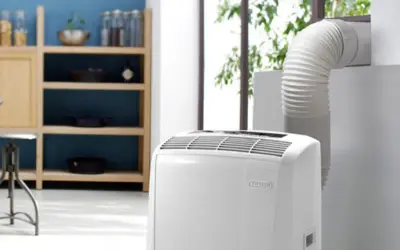 Climatiseur mobile blanc avec tuyau d'évacuation relié à une fenêtre.