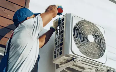 Un technicien installe une unité extérieure de climatisation réversible. Obtenez un devis pour le prix installation clim réversible.