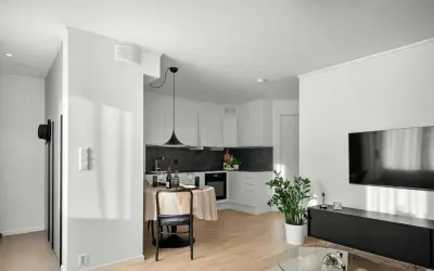 Un studio moderne avec cuisine, coin repas et salon. Un climatiseur discret est installé au plafond, assurant le confort.