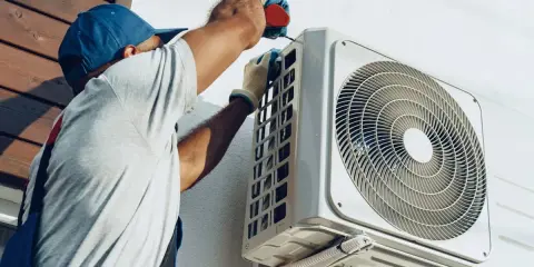 Un technicien installe une unité extérieure de climatisation réversible. Obtenez un devis pour le prix installation clim réversible.