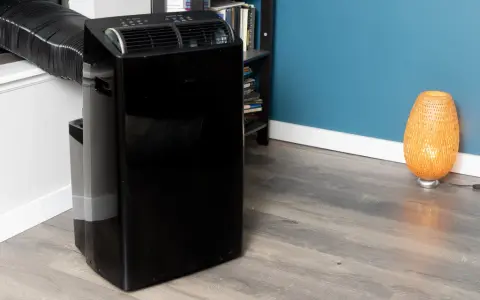 Climatiseur mobile noir avec tuyau d'évacuation. Le modèle aerian aac2300 est prêt à rafraîchir votre pièce.