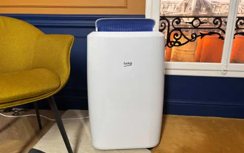 Climatiseur Beko, blanc, avec une sortie d'air bleue. Un fauteuil moutarde et une vue sur des toits parisiens. Avis positifs attendus.