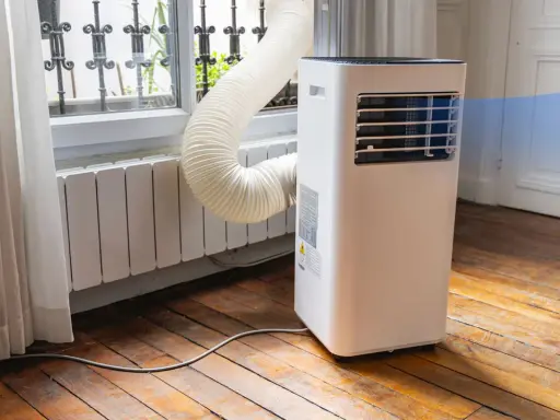 Climatiseur monobloc avec son tuyau d'évacuation vers la fenêtre. Un inconvénient : le tuyau peut être encombrant.