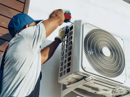 Un technicien installe une unité extérieure de climatisation réversible. Obtenez un devis pour le prix installation clim réversible.