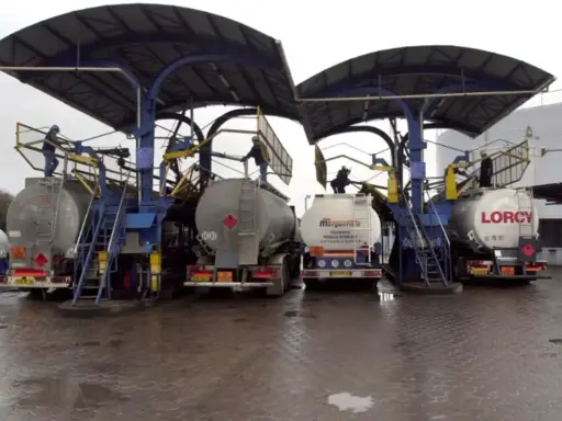 Camions citernes en cours de chargement sous des auvents. Le chauffage fioul prix est une préoccupation majeure pour les ménages.