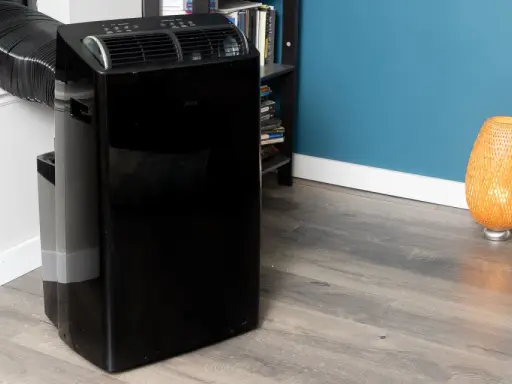 Climatiseur mobile noir avec tuyau d'évacuation. Le modèle aerian aac2300 est prêt à rafraîchir votre pièce.