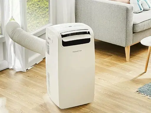 Climatiseur mobile Rowenta, la meilleur marque climatiseur mobile pour un confort optimal. Un appareil blanc avec un tuyau d'évacuation vers la fenêtre.