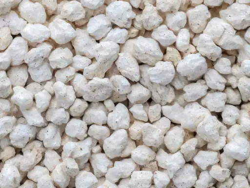 Gros plan sur des granulés blancs et irréguliers, parfaits pour la perlite isolation.