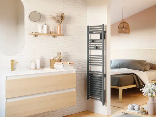 Salle de bain moderne avec meuble vasque, miroir ovale et sèche-serviettes gris. La puissance du sèche serviette assure des serviettes chaudes.