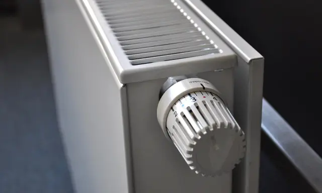 Gros plan sur un radiateur blanc, avec son thermostat réglable. Ce radiateur fonte ou céramique est prêt à chauffer votre intérieur.