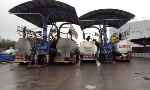 Camions citernes en cours de chargement sous des auvents. Le chauffage fioul prix est une préoccupation majeure pour les ménages.