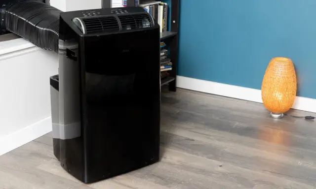 Climatiseur mobile noir avec tuyau d'évacuation. Le modèle aerian aac2300 est prêt à rafraîchir votre pièce.