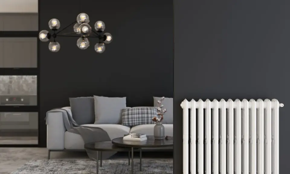 Un salon moderne avec un canapé gris, une table basse et un lustre design. À droite, un radiateur blanc classique, rappelant les anciens panneaux rayonnants.