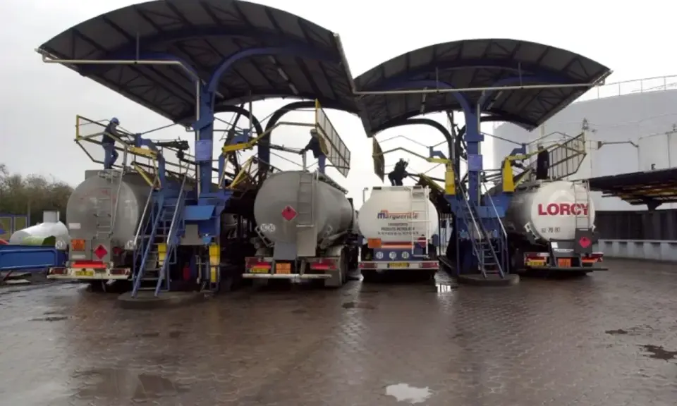 Camions citernes en cours de chargement sous des auvents. Le chauffage fioul prix est une préoccupation majeure pour les ménages.