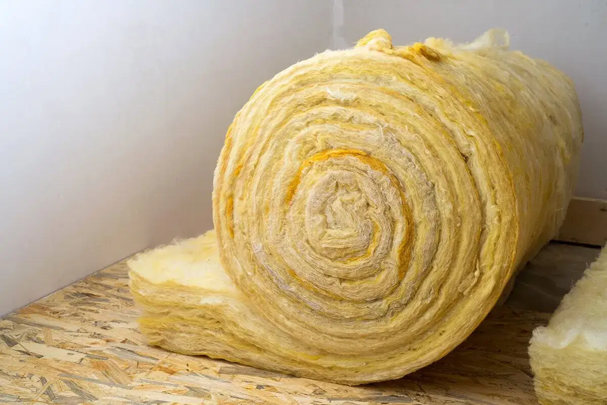 Rouleaux de laine de roche sur un panneau OSB, pr&ecirc;ts pour l'isolation. Ce mat&eacute;riau offre de bons avantages thermiques et acoustiques, mais attention &agrave; ses inconv&eacute;nients lors de la manipulation.