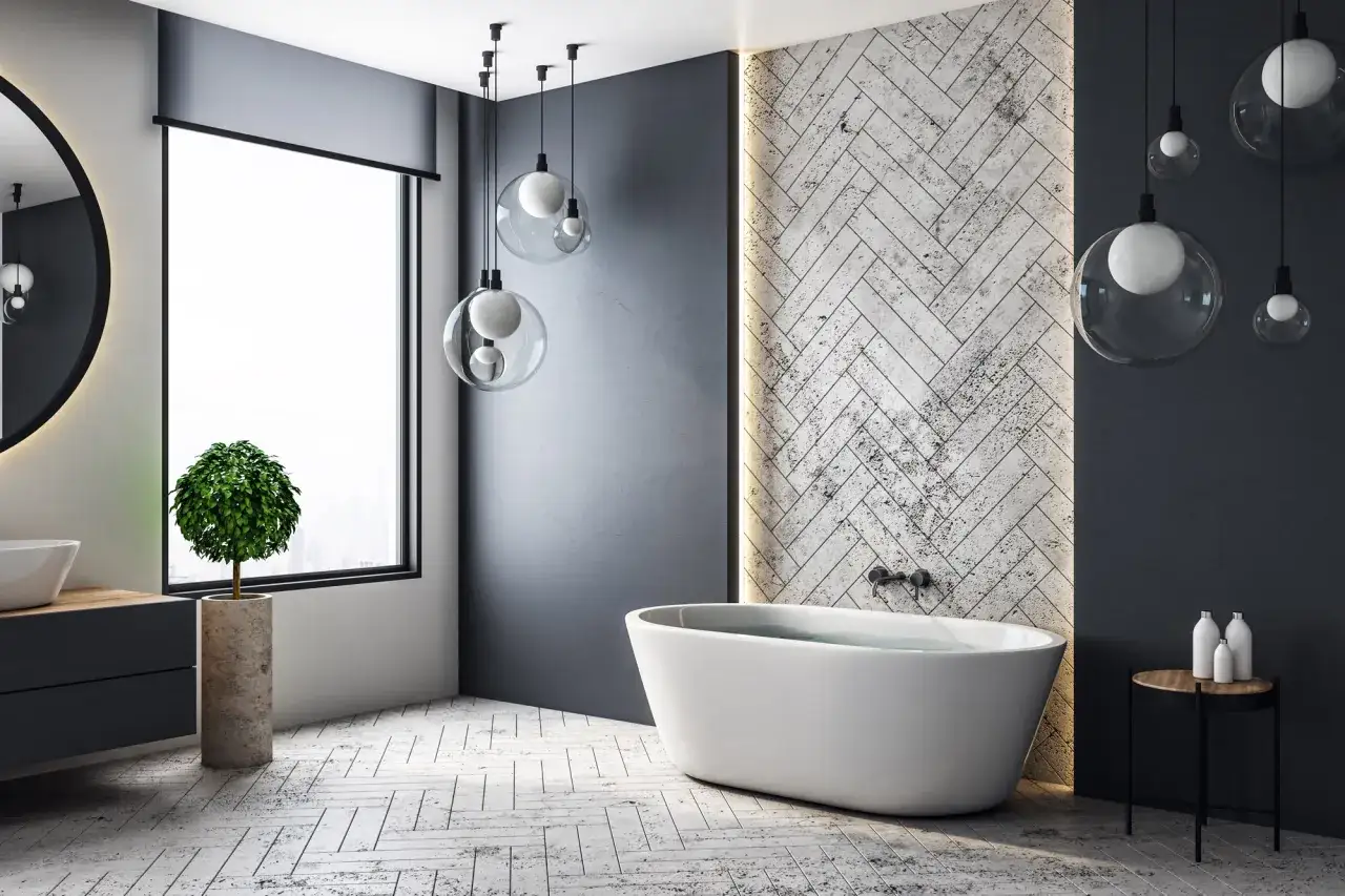 Bain moderne avec baignoire &icirc;lot, lavabo, miroir rond et plante verte. L'ambiance d'isolation salle de bain est accentu&eacute;e par les lumi&egrave;res suspendues.