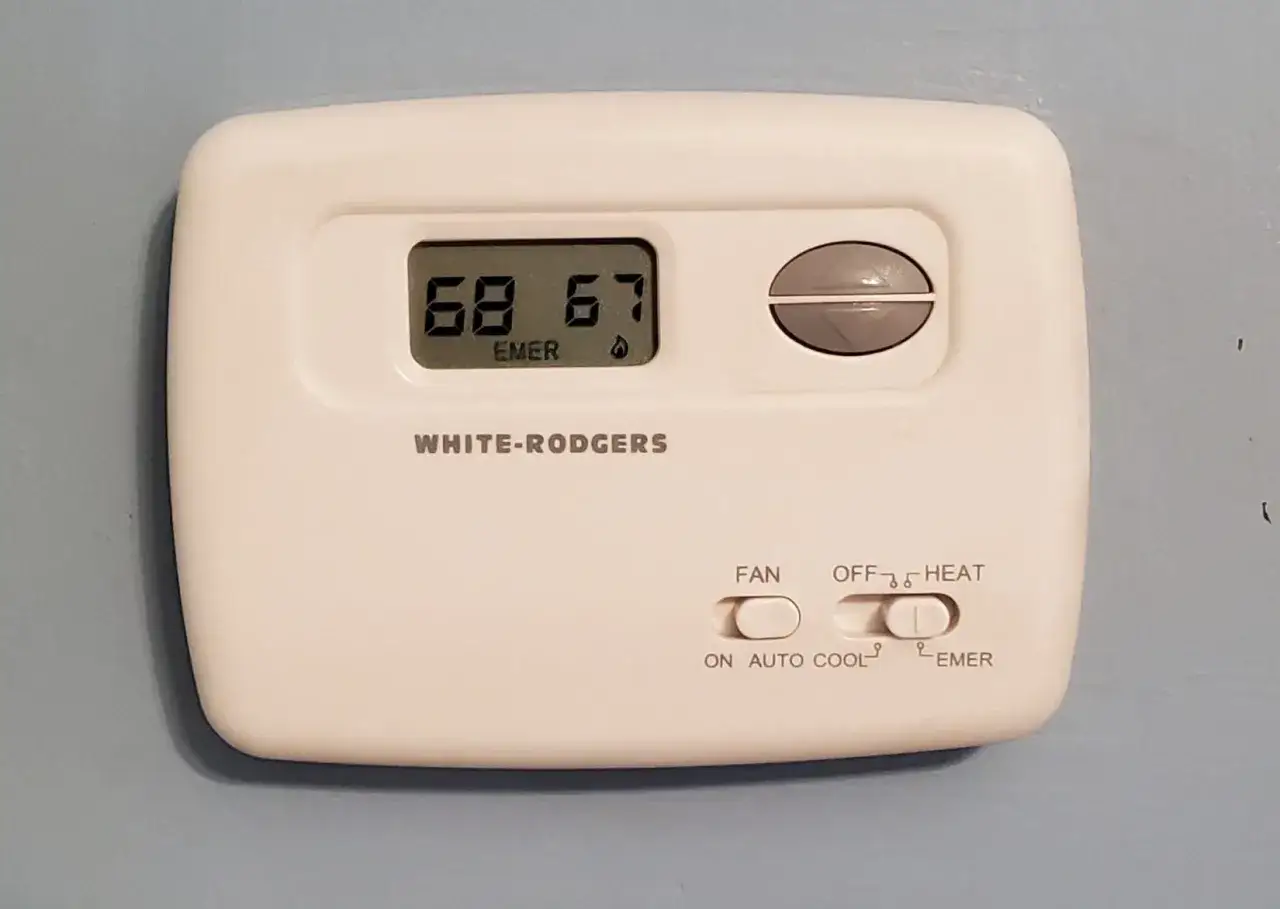 Thermostat White-Rodgers affichant 68°F. Le mode 