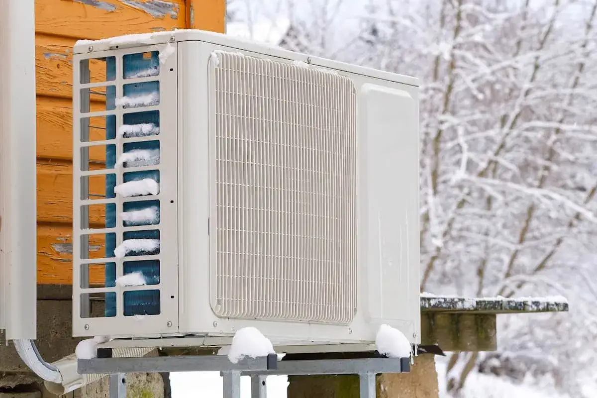 Unit&eacute; ext&eacute;rieure de climatisation recouverte de neige, t&eacute;moignant du froid hivernal. La temp&eacute;rature clim hiver est bien pr&eacute;sente.