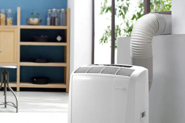 Climatiseur mobile blanc avec tuyau d'évacuation relié à une fenêtre.