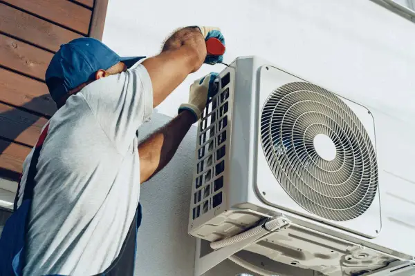 Un technicien installe une unité extérieure de climatisation réversible. Obtenez un devis pour le prix installation clim réversible.